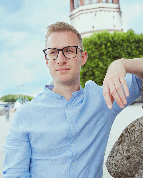 Mann in Jeansjacke trägt stylische Brille in Düsseldorf