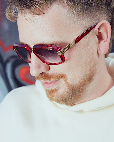 Mann in Jeansjacke trägt stylische Brille in Düsseldorf