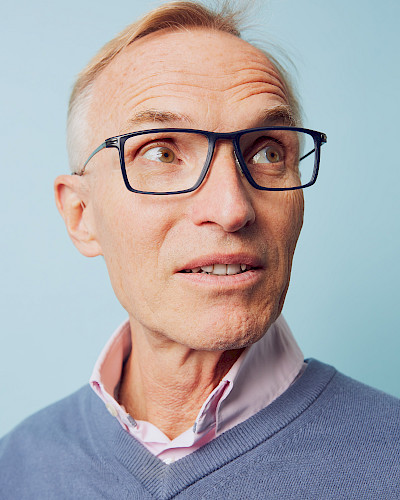 Mann in Jeansjacke trägt stylische Brille in Düsseldorf