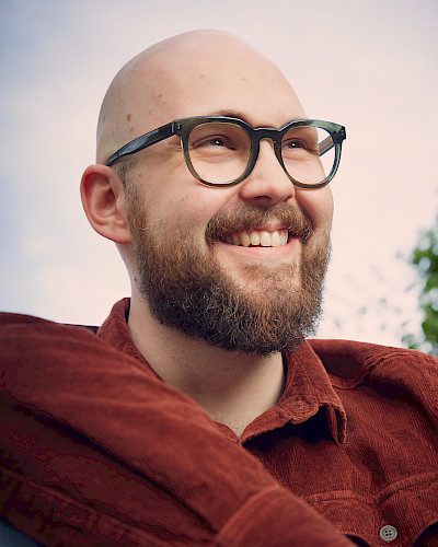 Mann in Jeansjacke trägt stylische Brille in Düsseldorf