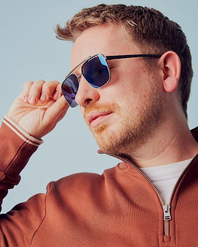 Mann in Jeansjacke trägt stylische Brille in Düsseldorf